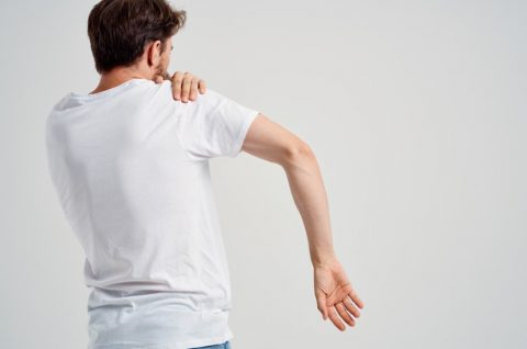 man-white-t-shirt-holding-shoulder