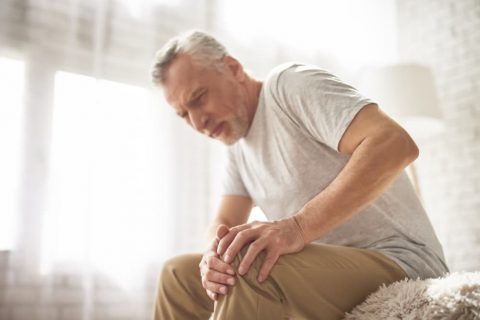 retired-man-pensioner-suffering-knee-pain-home