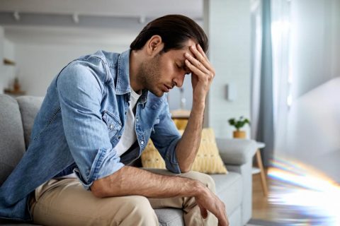 young-man-having-headache-holding-his-head-pain-home